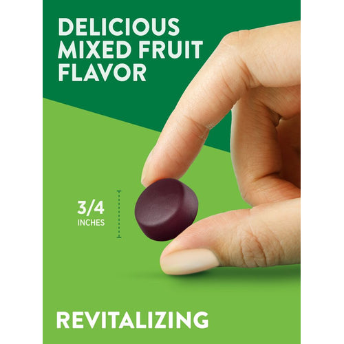 A hand holds a dark purple, mixed fruit flavored gummy measuring three-quarters of an inch, shown on a bulk scale.
